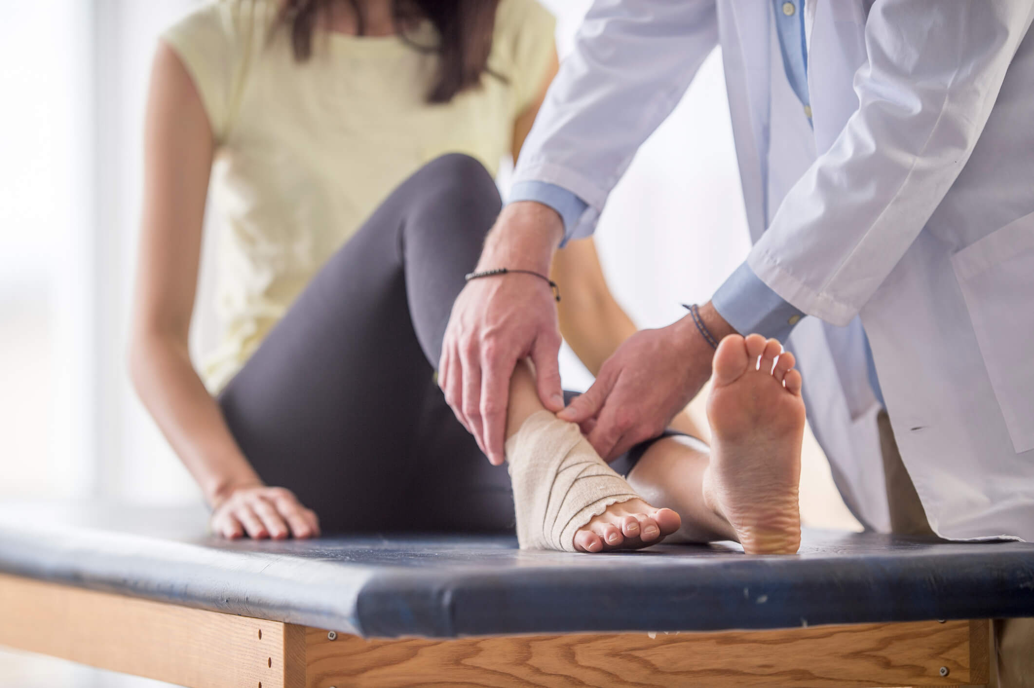 Doctor wrapping a woman's burned ankle